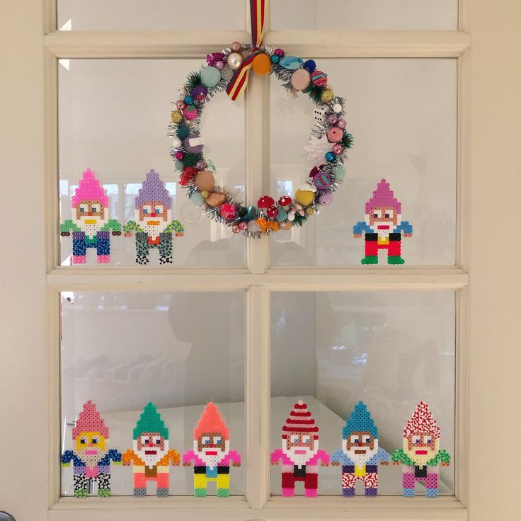 a christmas wreath made out of legos in front of a window with other decorations