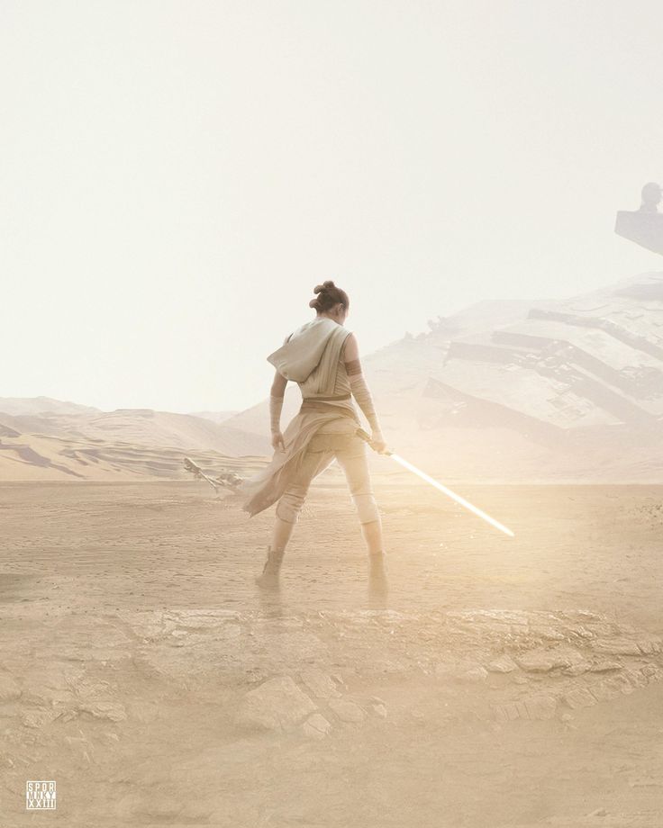 a woman holding a light saber in the desert