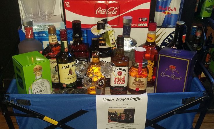 a cart full of liquor bottles sitting on top of a wooden floor next to a sign