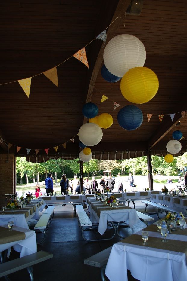 tables and chairs are set up for an event with paper lanterns hanging from the ceiling