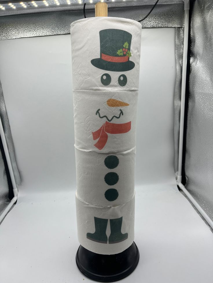 a snowman made out of toilet paper with a top hat and scarf on it