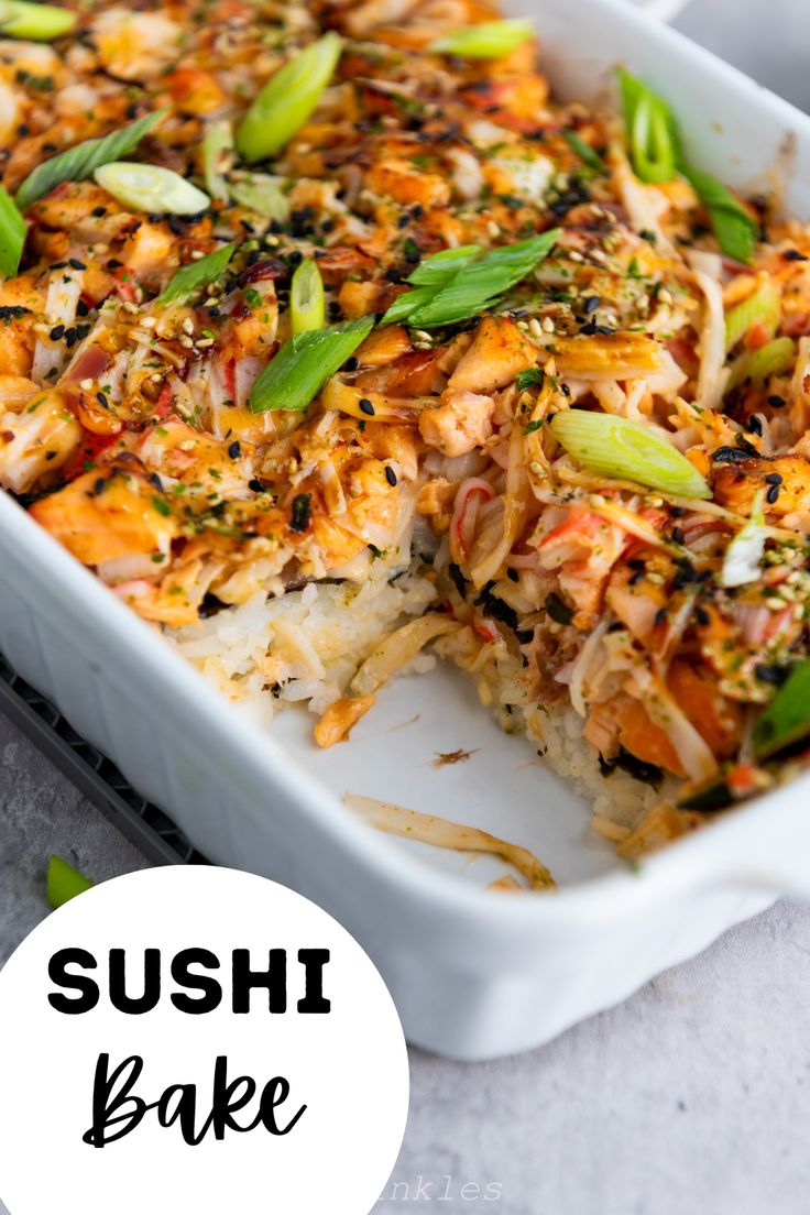 sushi bake in a white casserole dish with green onions and sesame seeds