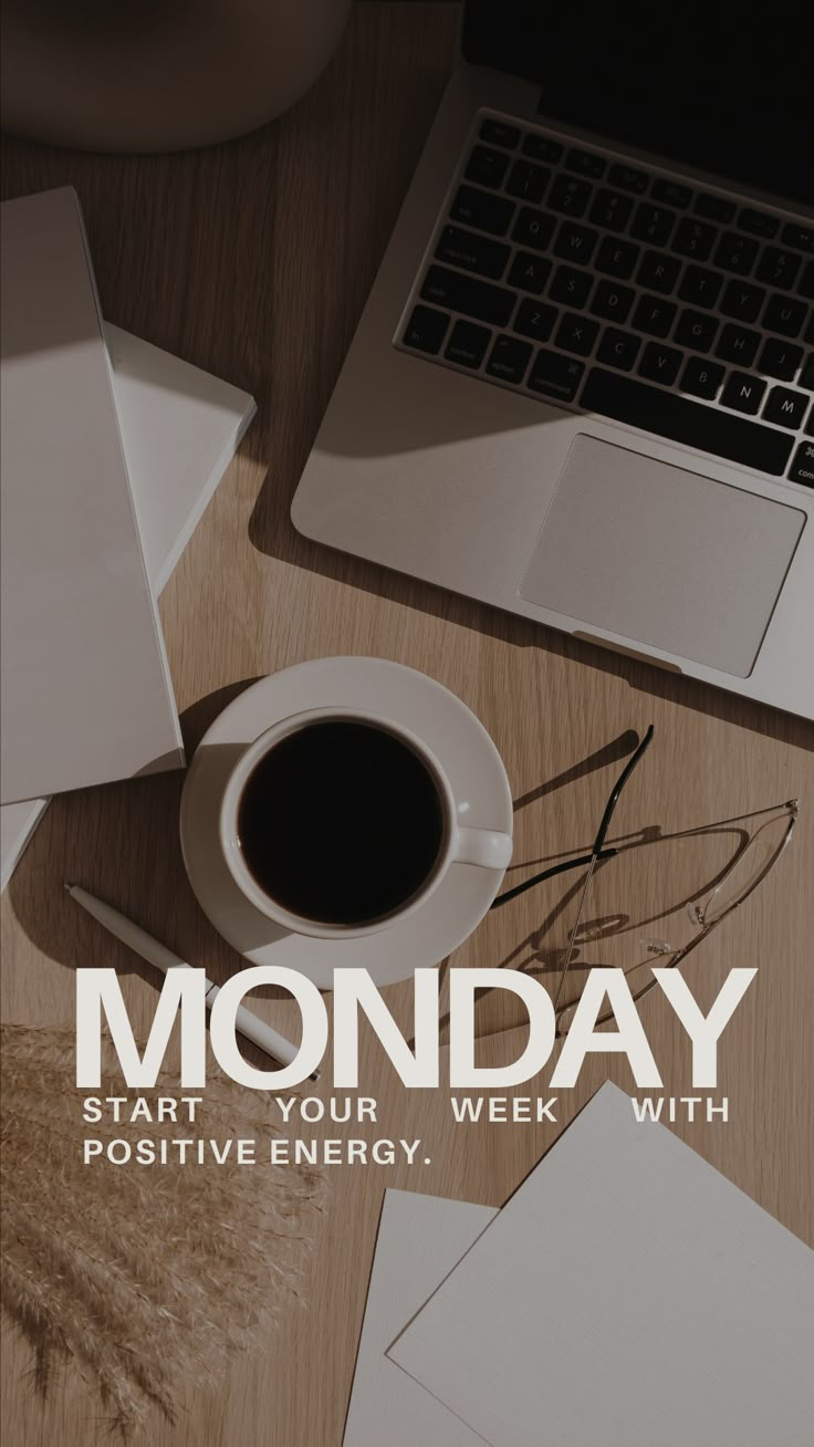 a cup of coffee sitting on top of a wooden table next to a laptop computer