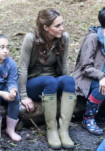 the duke and duchess of cambridge are sitting on a log with their feet propped up