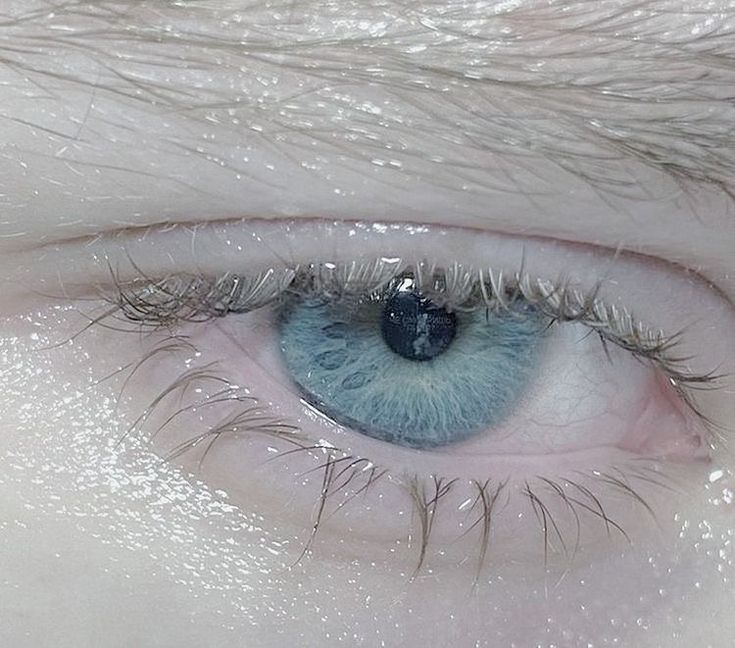 a close up view of an eye with blue eyes