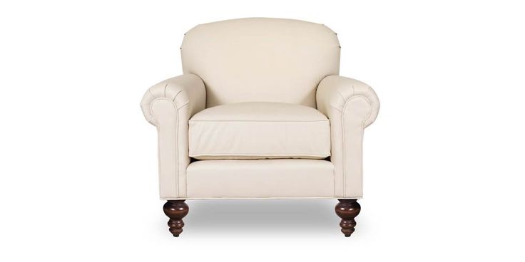 a white leather chair with wooden legs