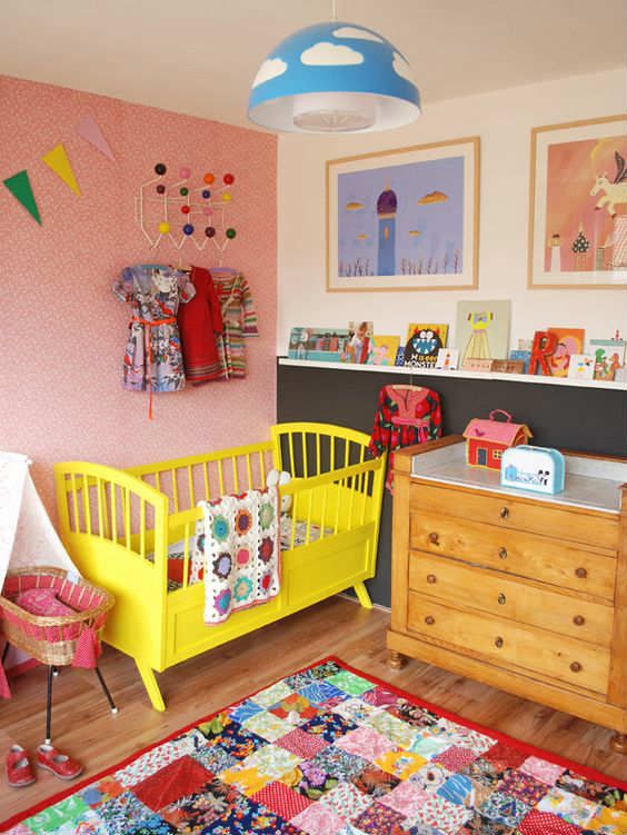 a child's room with pink walls and yellow furniture