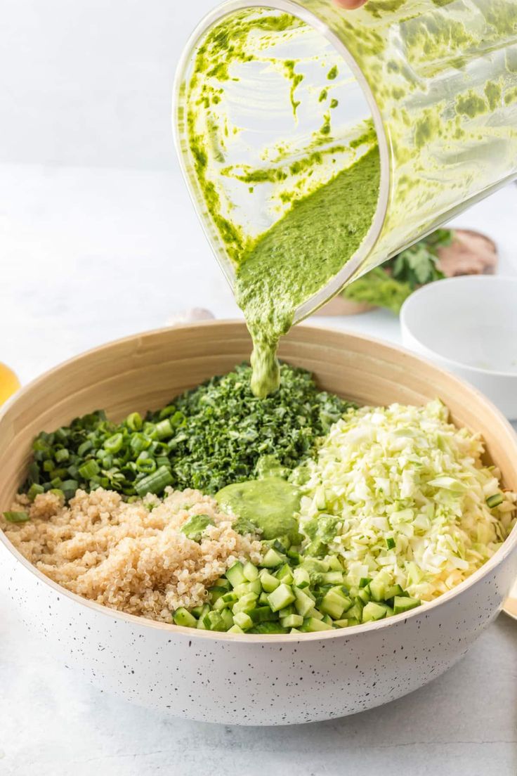 someone pouring dressing into a bowl filled with vegetables