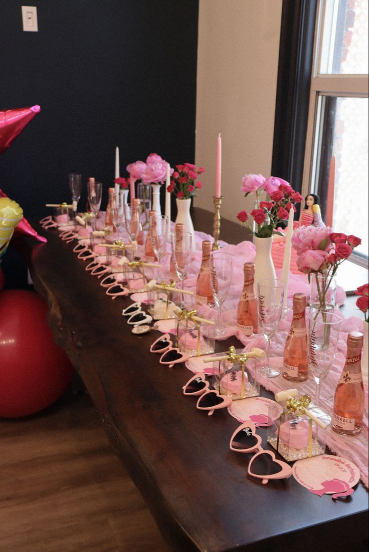 a long table with pink flowers and glasses on it