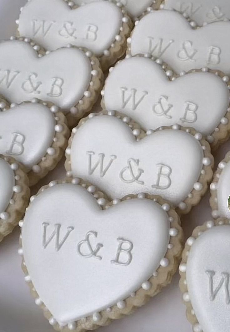 decorated cookies in the shape of hearts with names and initials on them are arranged together