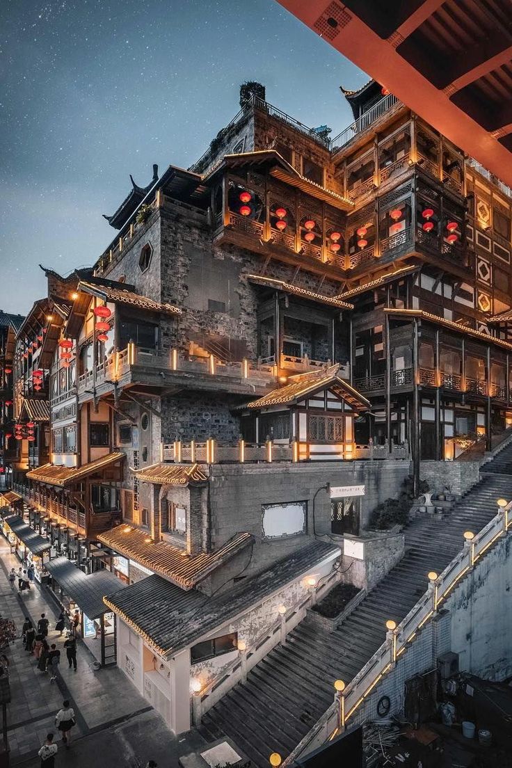 an old building is lit up at night with red lights on the windows and stairs