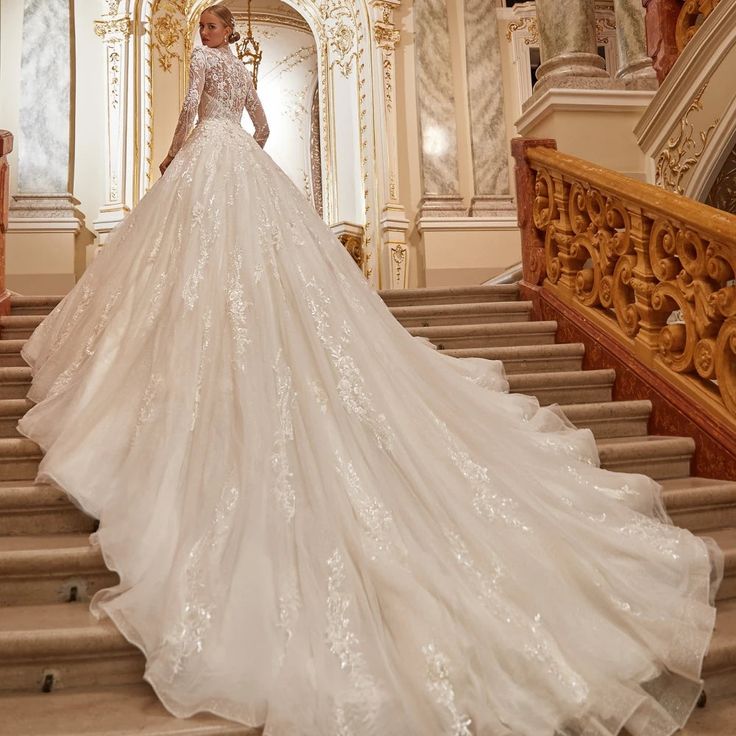 a woman in a wedding dress standing on some stairs