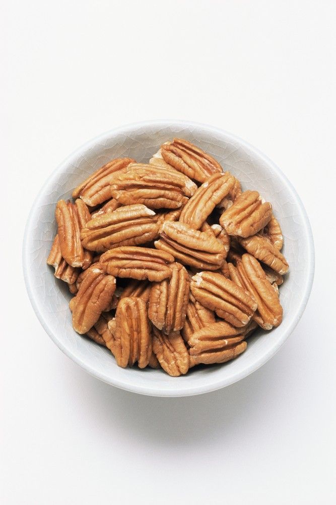 a white bowl filled with nuts on top of a table