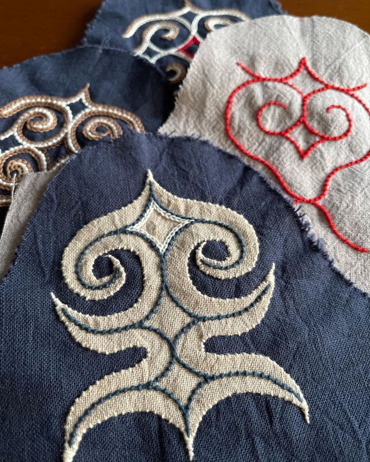 three different designs are on the back of an old jacket that has been stitched together