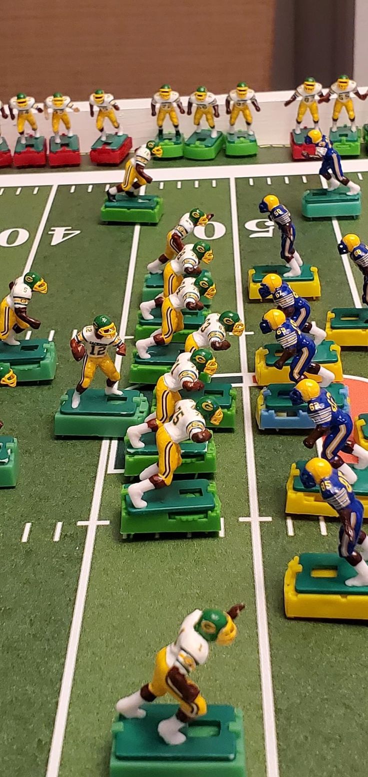 many toy football players are lined up on the field to play against each other in a game