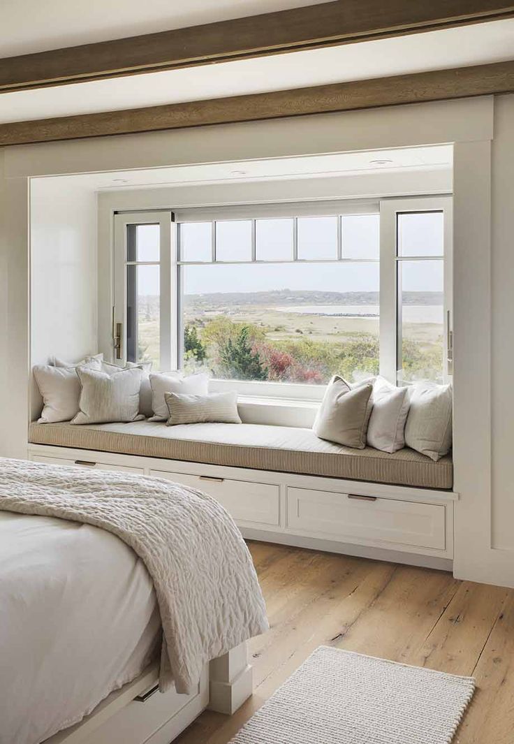 a bedroom with a large window seat next to a bed