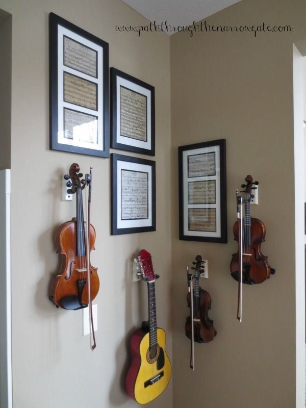 three guitars are hanging on the wall with music memorabilia around them and two framed pictures