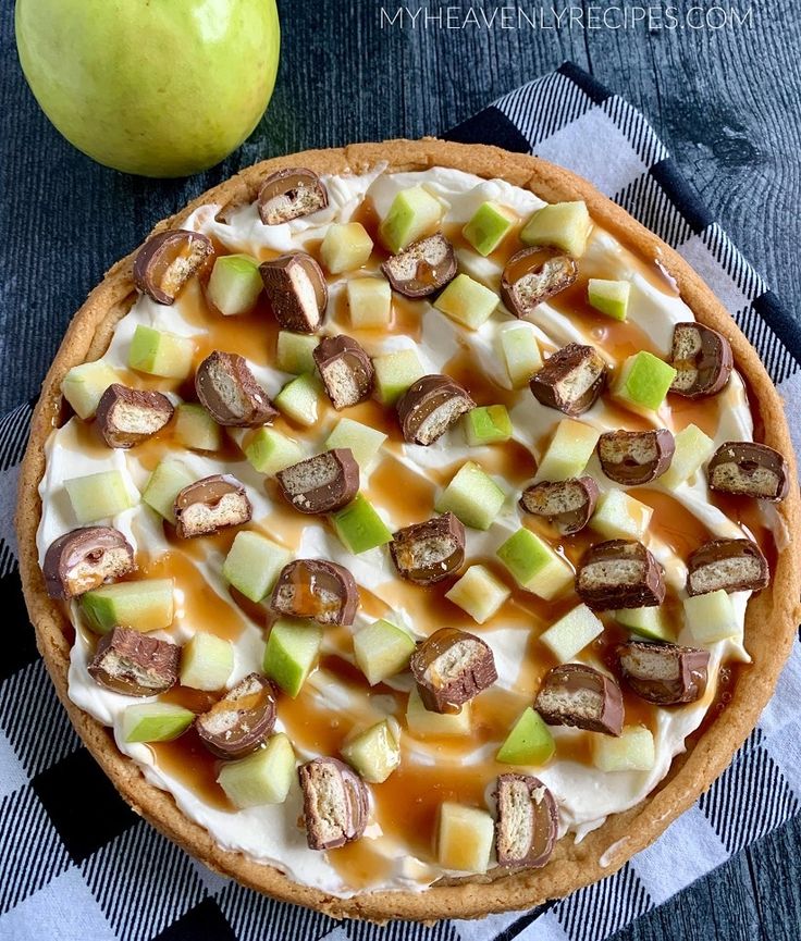 an apple pie with caramel, apples and whipped cream on top is ready to be eaten