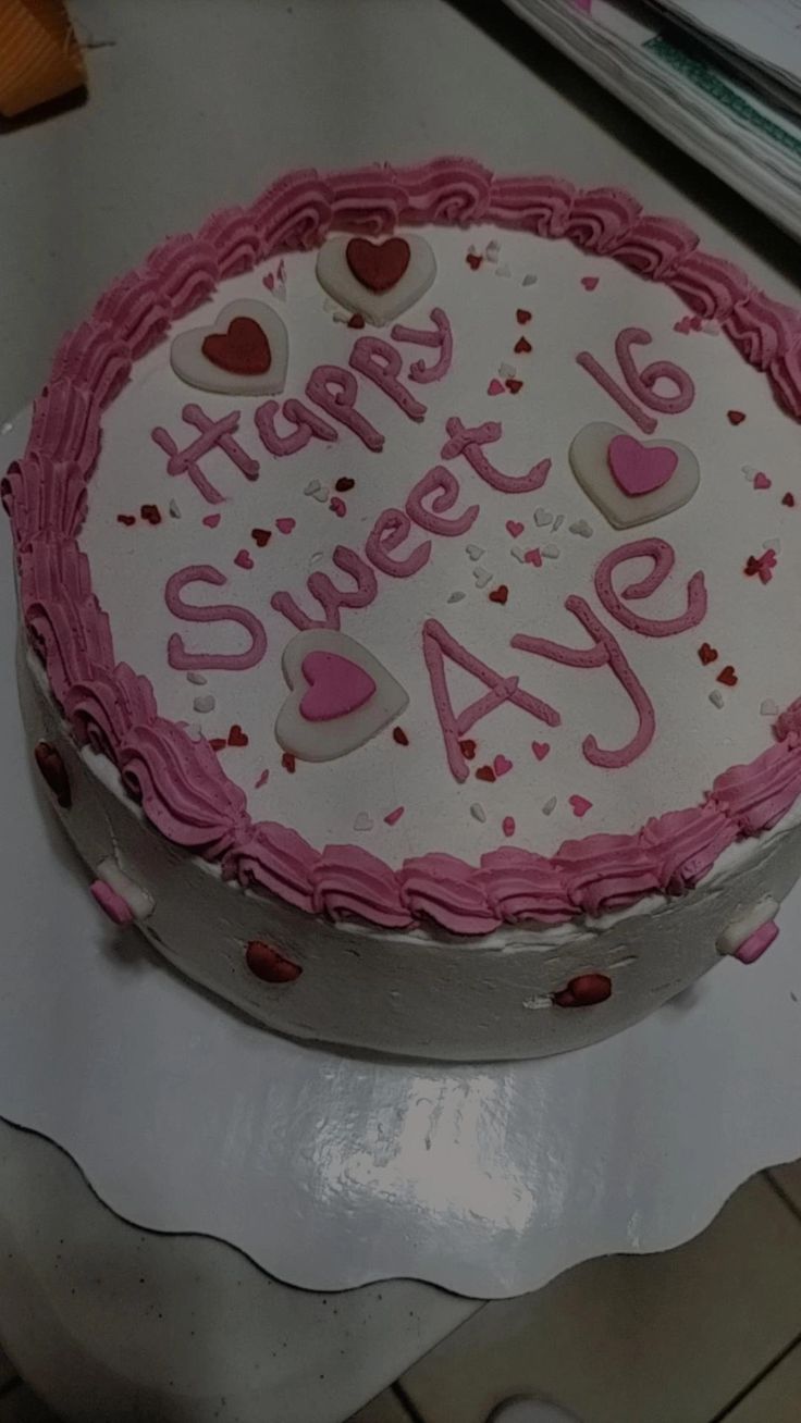 a white cake with pink frosting and hearts on it that says happy sweet day