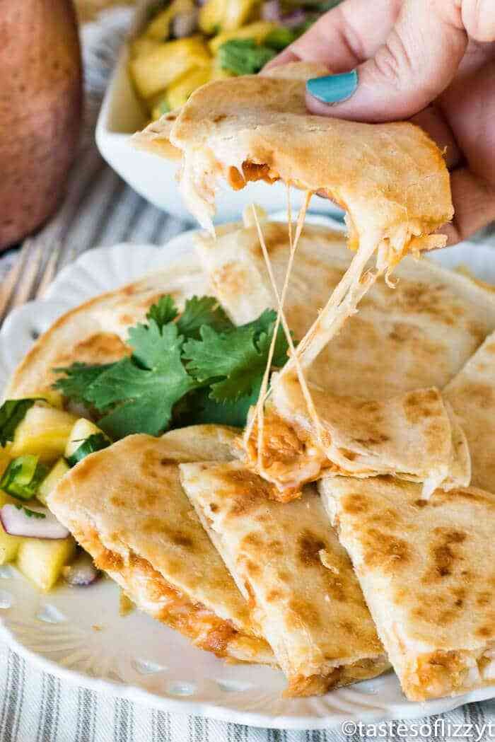 a plate with quesadillas on it being lifted from the plate