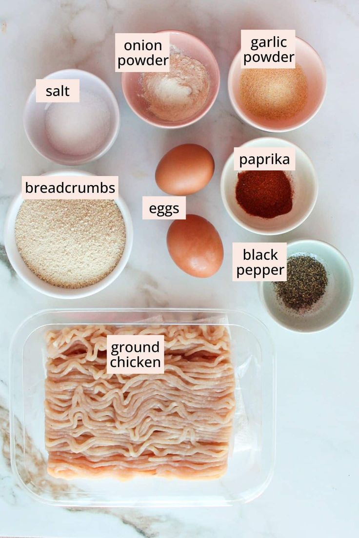 the ingredients for chicken soup in bowls on a marble counter top, including eggs, ground pepper, garlic, salt, and paprika