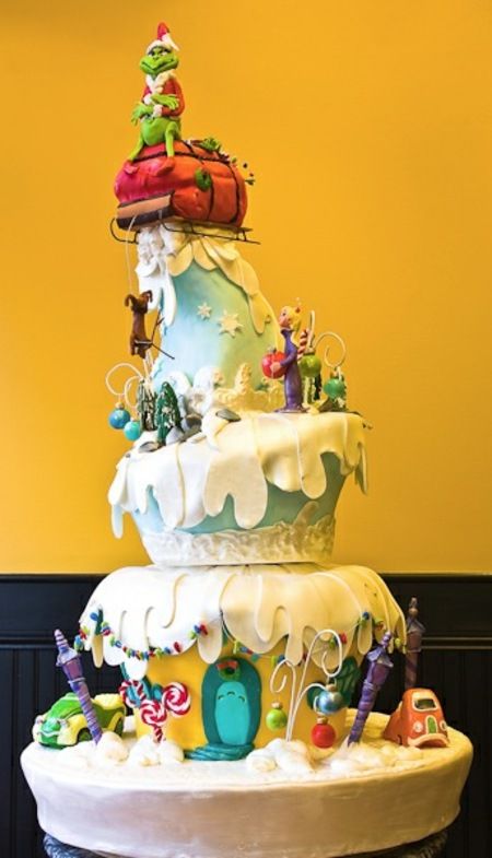 a three tiered cake is decorated with toys and frosting on the top layer