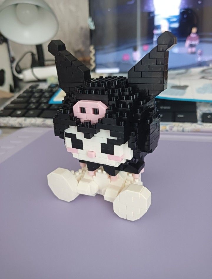 a black and white cat made out of legos on top of a purple table