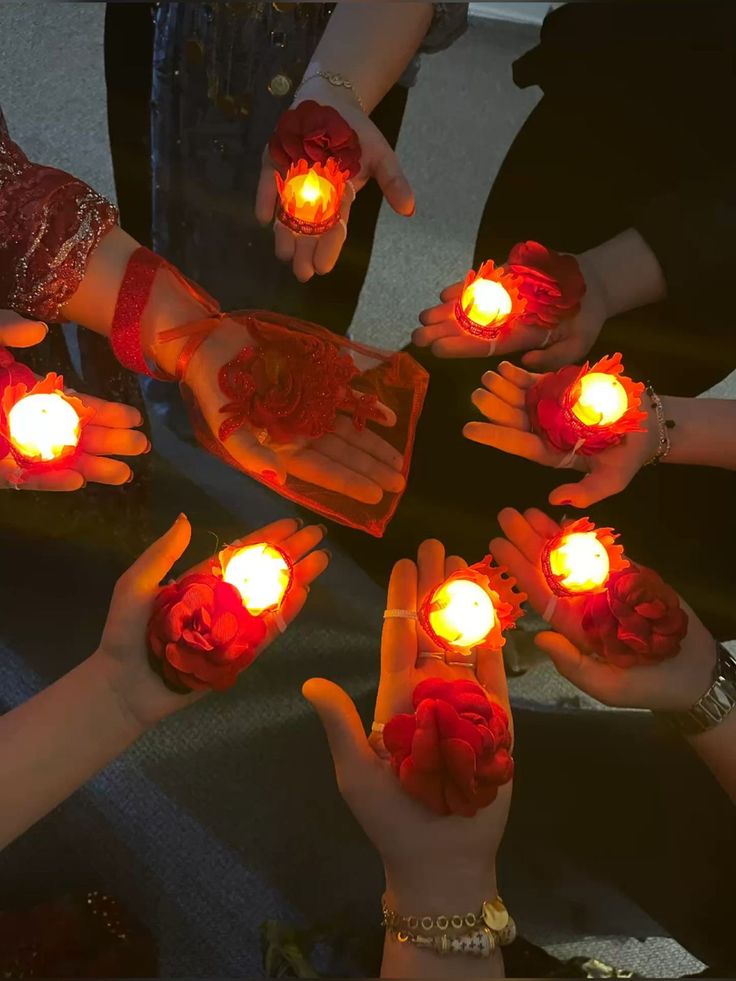 several people holding lighted candles in their hands