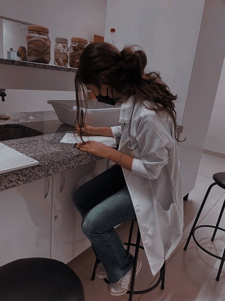 a woman sitting at a counter using her cell phone