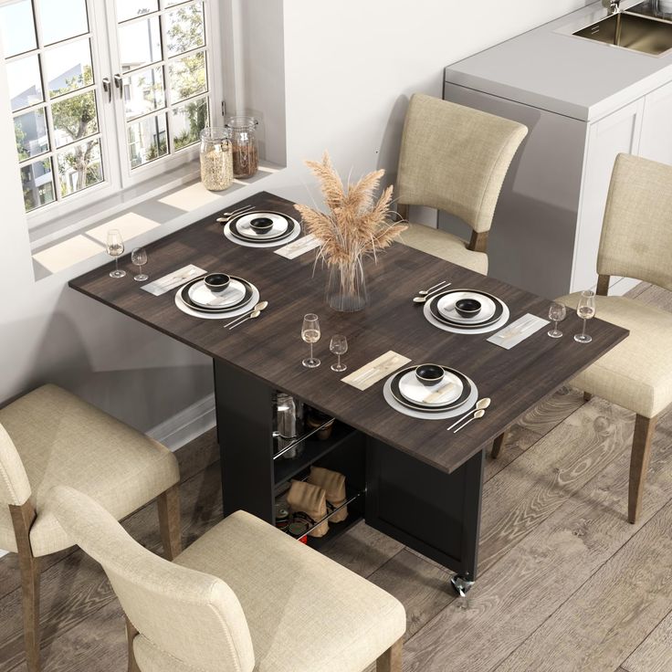 a dining room table with four chairs and plates on the placemats in front of it