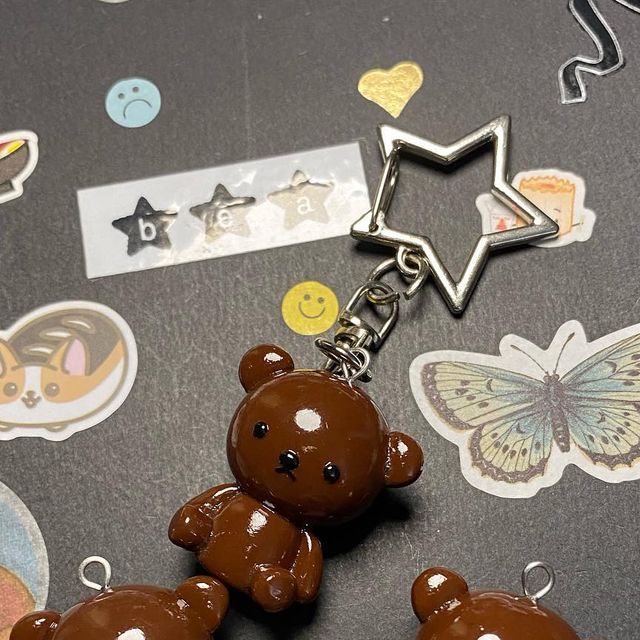 two brown teddy bears sitting next to each other on top of a table with stickers