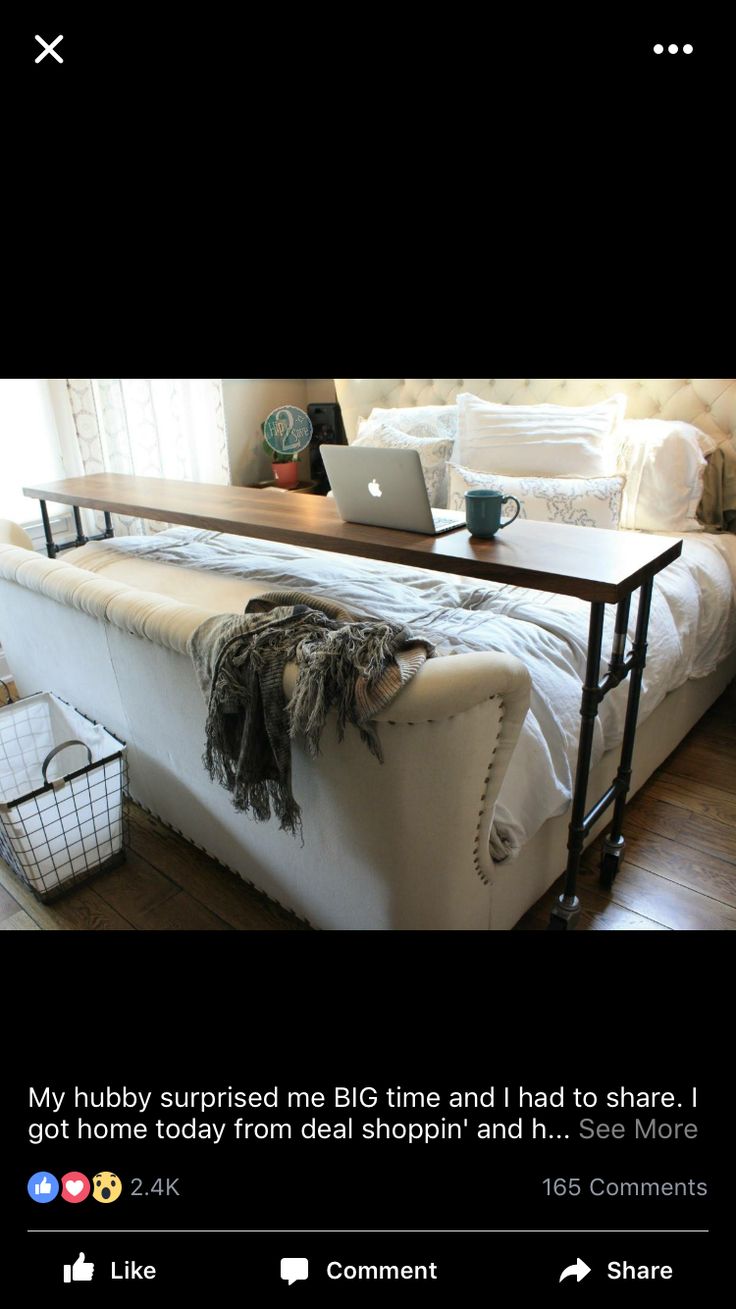 a white couch sitting in front of a laptop computer on top of a wooden table