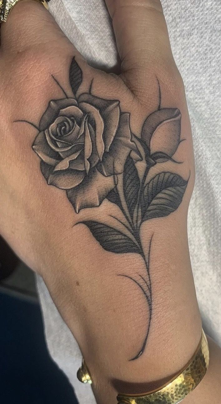 a woman's arm with a rose tattoo on the left side of her hand