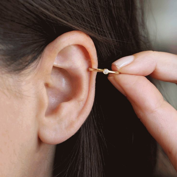 Gold thread in a round profile that wraps and hugs the ear perfectly. The earring is set with a white diamond, which will give your ear an elegant sparkle. The back of the earring is specially designed to be soft and round in contact with the body. No piercing required! How to wear? : slip it on the top narrowest part of your ear and slide it down to adjust, whatch the video ! The earrings are sold as singles All features can be customized! Please contact us if you wish to make changes; we love 14k White Gold Single Ear Cuff, Minimalist Diamond Cartilage Single Earring, Single Diamond Cartilage Earring In Minimalist Style, Minimalist Diamond Single Cartilage Earring, Minimalist Single Diamond Cartilage Earring, Elegant Yellow Gold Internally Threaded Ear Cuff, Minimalist Gold Diamond Ear Cuff, Yellow Gold Minimalist Ear Cuff, Single 14k White Gold Ear Cuff