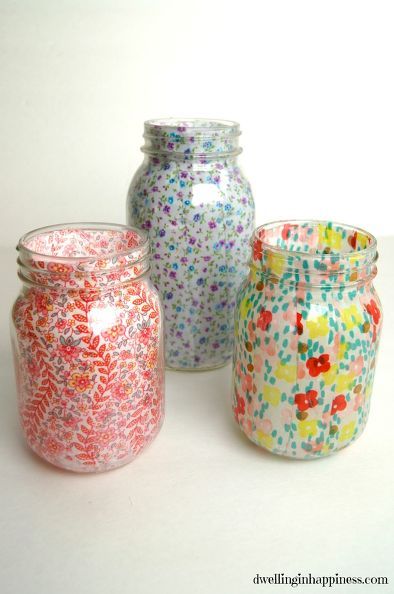 three jars with different designs on them sitting next to each other