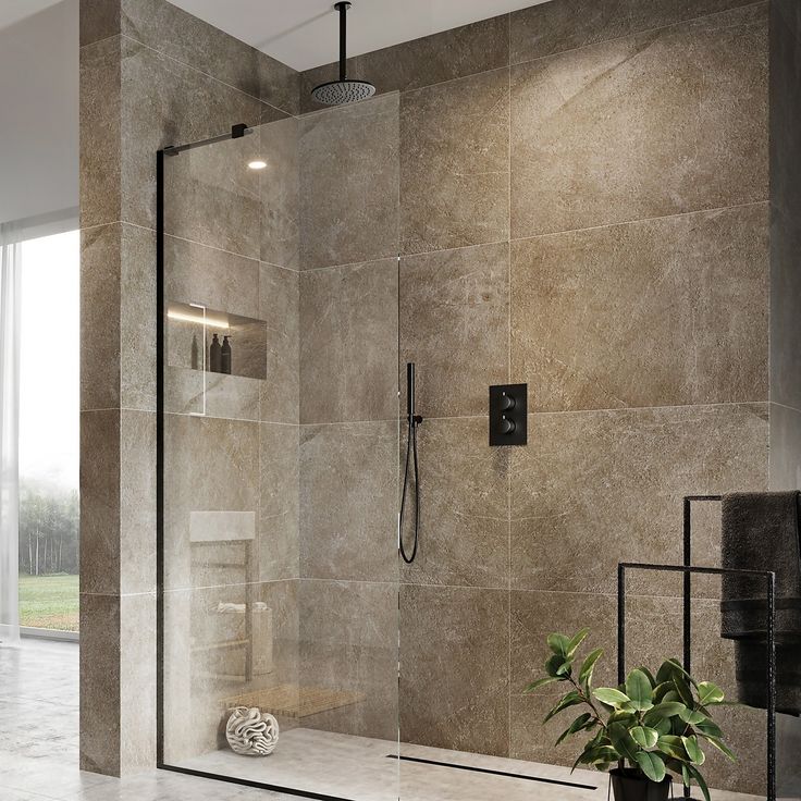 a bathroom with a walk in shower next to a potted plant