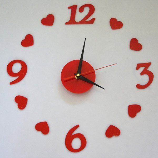 a clock with red numbers and hearts on it