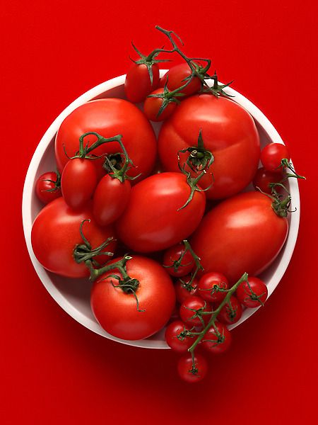 a white bowl filled with lots of red tomatoes