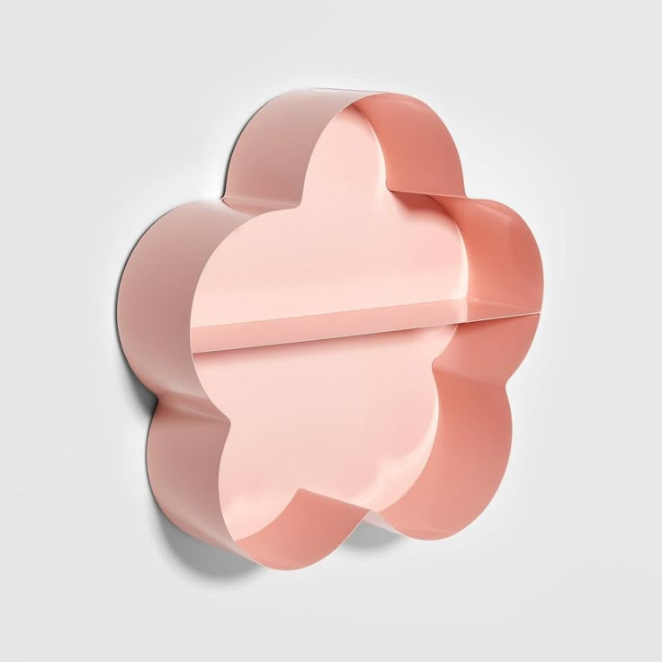 a pink flower shaped object on a white wall