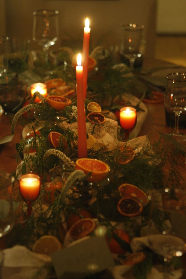 a table topped with lots of candles next to plates and bowls filled with food on top of it