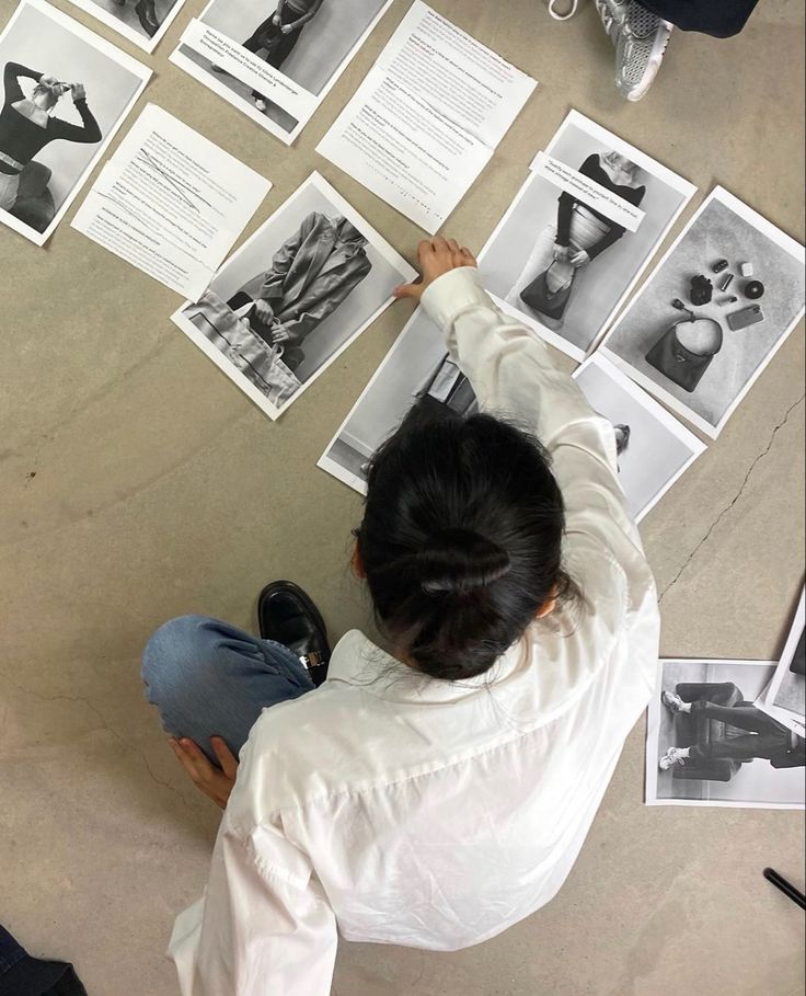 a person sitting on the ground with their hands up in front of them and many pictures