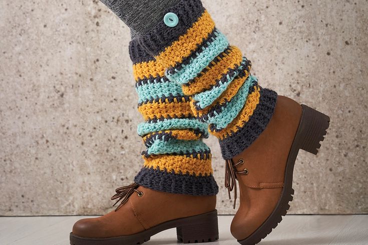 a person wearing brown boots and socks with colorful knitted leg warmers on their legs