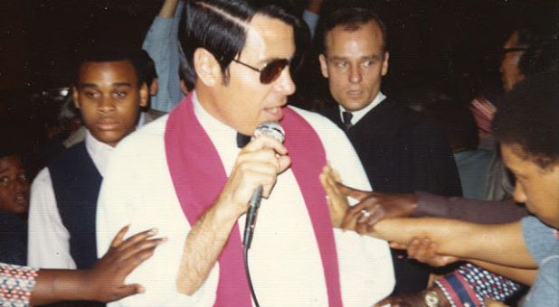 a man with a microphone surrounded by people