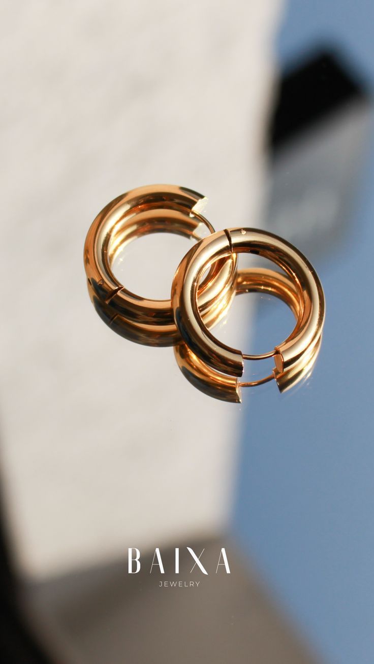 two gold rings hanging from the side of a building