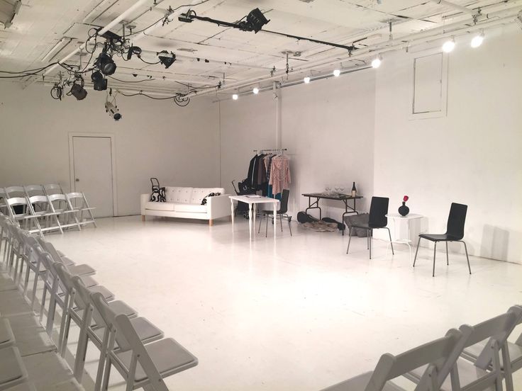 an empty white room with chairs and tables