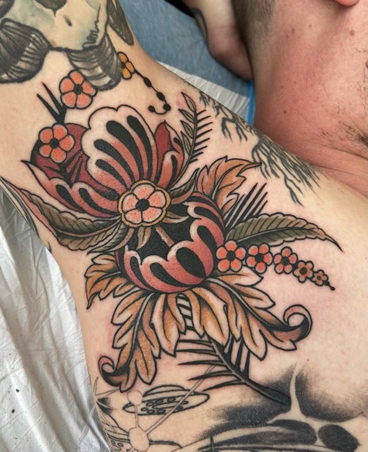 a close up of a man's chest with flowers and birds tattoo on it