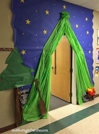 a classroom decorated for christmas with decorations and trees on the wall, in front of an open door