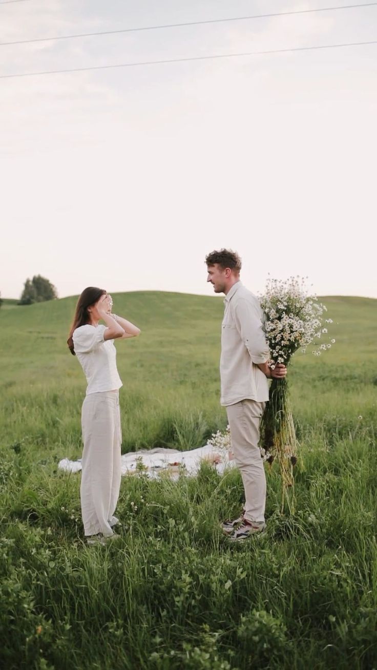 a man and woman standing next to each other in a field