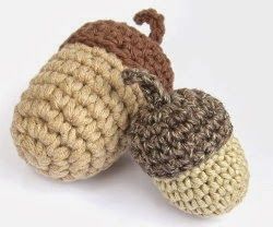 two crocheted acorns sitting next to each other