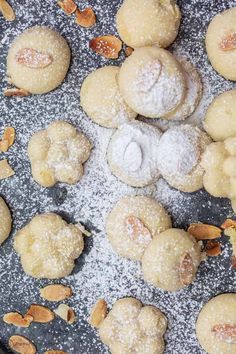 powdered sugar cookies and almonds on a baking sheet